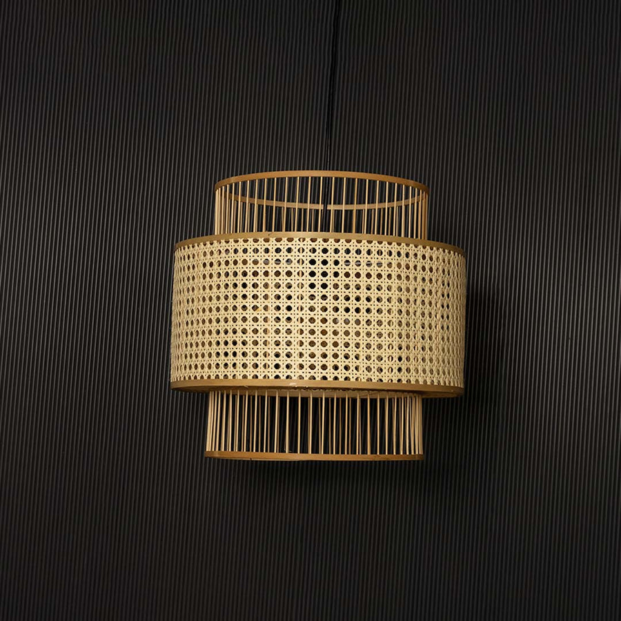 Natural rattan pendant light displayed off on black background showing elegant handcrafted layered design.