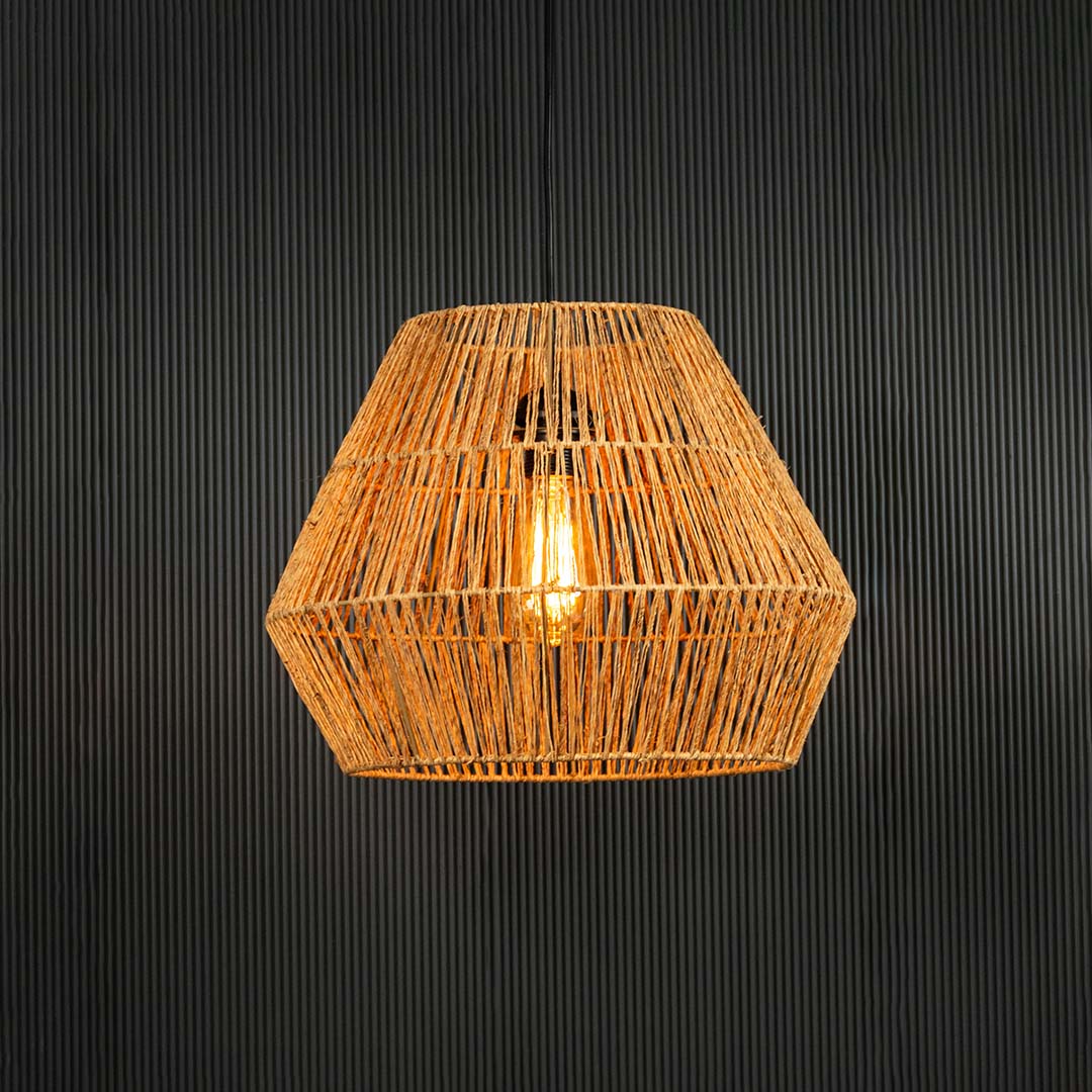 Handwoven jute pendant light illuminated on back background for bohemian dining room and cafe ceiling decor lighting.