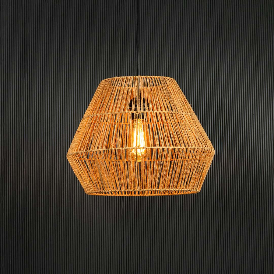 Handwoven jute pendant light illuminated on back background for bohemian dining room and cafe ceiling decor lighting.