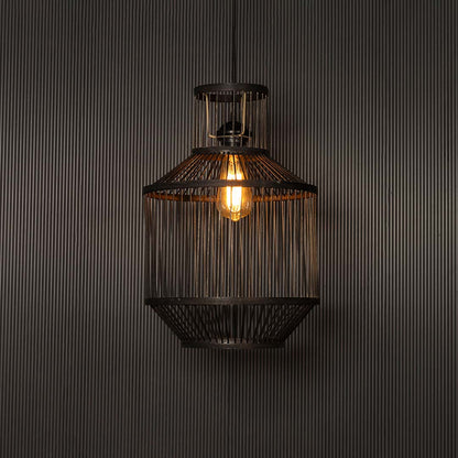 Wire pendant light glowing warmly on black background revealing intricate lines and elegant industrial design.