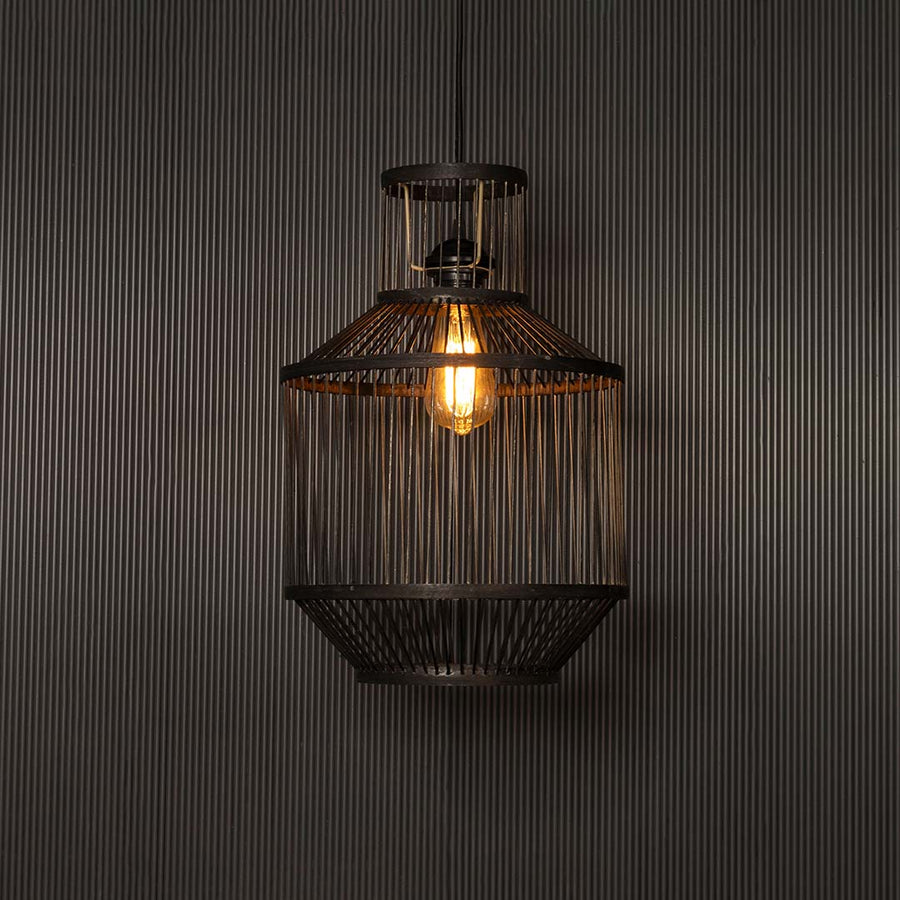 Wire pendant light glowing warmly on black background revealing intricate lines and elegant industrial design.