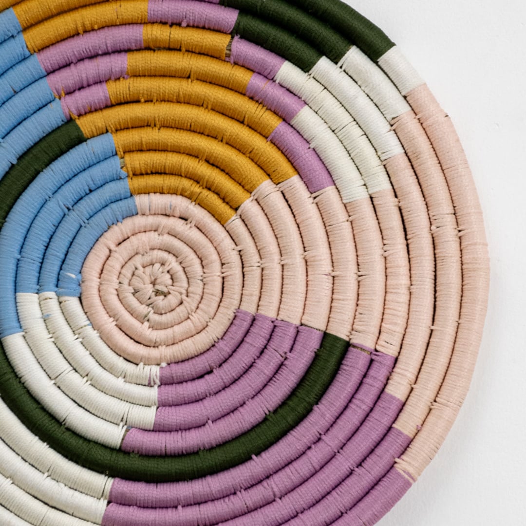 Handwoven round wall basket in multicolor pastel tones showing 40 cm diameter suitable for statement interior wall decor placement.