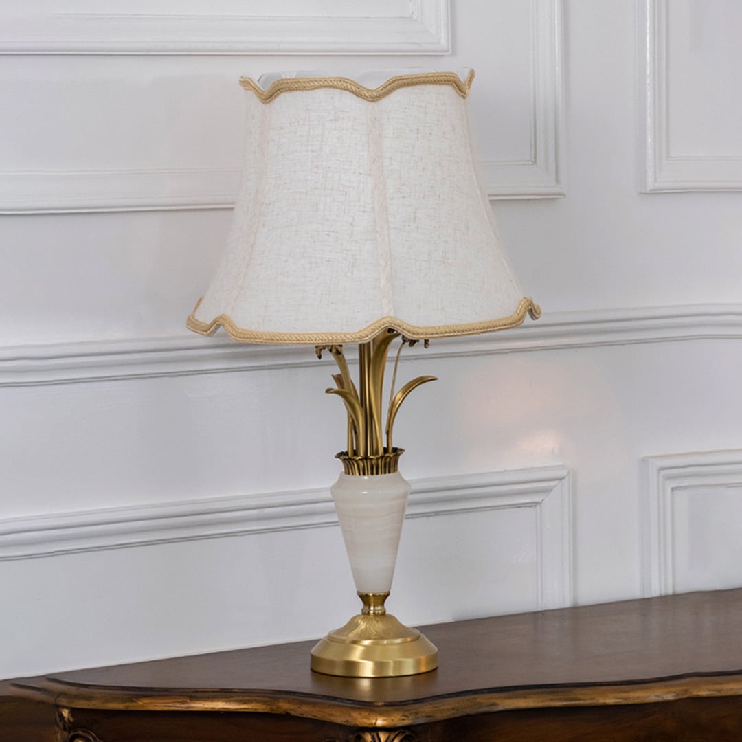 Gold and white marble base table lamp with cream fabric shade turned off against white background home decor table lamp.