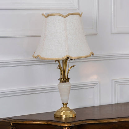 Gold and white marble base table lamp with cream fabric shade turned off against white background home decor table lamp.