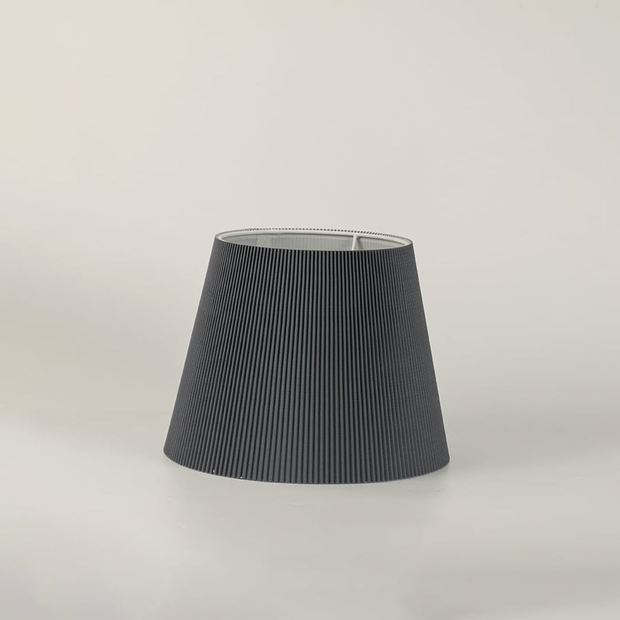 Grey pleated fabric lampshade showcasing textured craftsmanship and elegant detailing for refined decorative table lighting.
