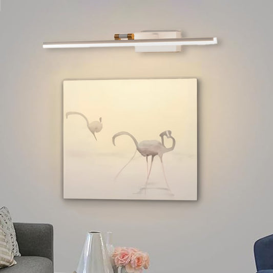 Lifestyle closeup of white and gold metal picture light enhancing artwork with warm focused gallery style illumination.