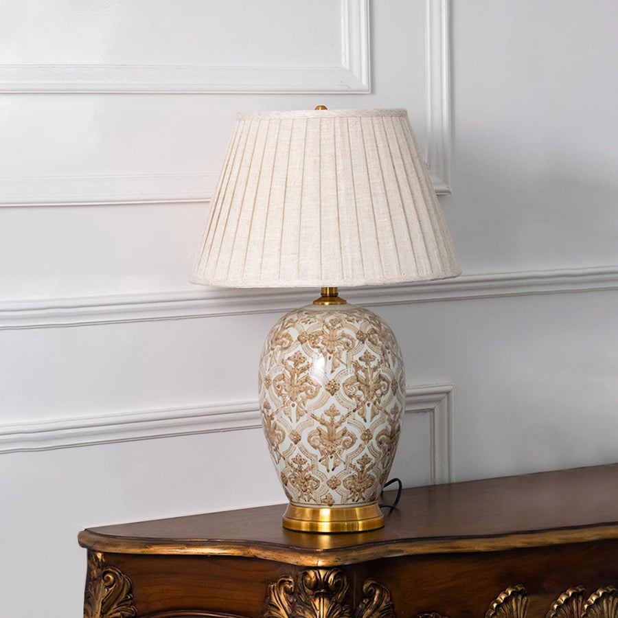 Ceramic damask design table lamp with golden base and pleated shade switched off for elegant modern home lighting style.