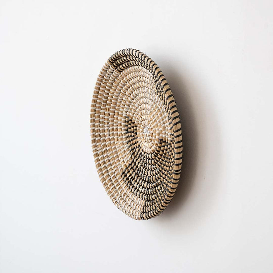 Side view of handwoven wicker basket wall decor showing woven depth and texture for rustic and boho home interiors.