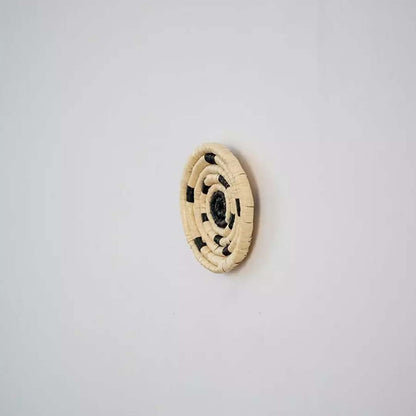Side profile of handwoven bamboo wall plate in yellow beige shades highlighting detailed weave and natural texture.