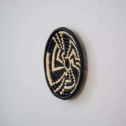 Side profile view of handwoven basket wall plate showing depth sturdy weaving and artisanal handcraft quality.