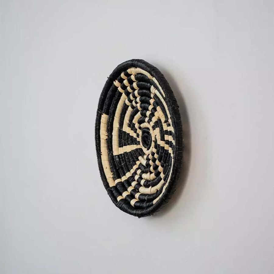 Side profile view of handwoven basket wall plate showing depth sturdy weaving and artisanal handcraft quality.
