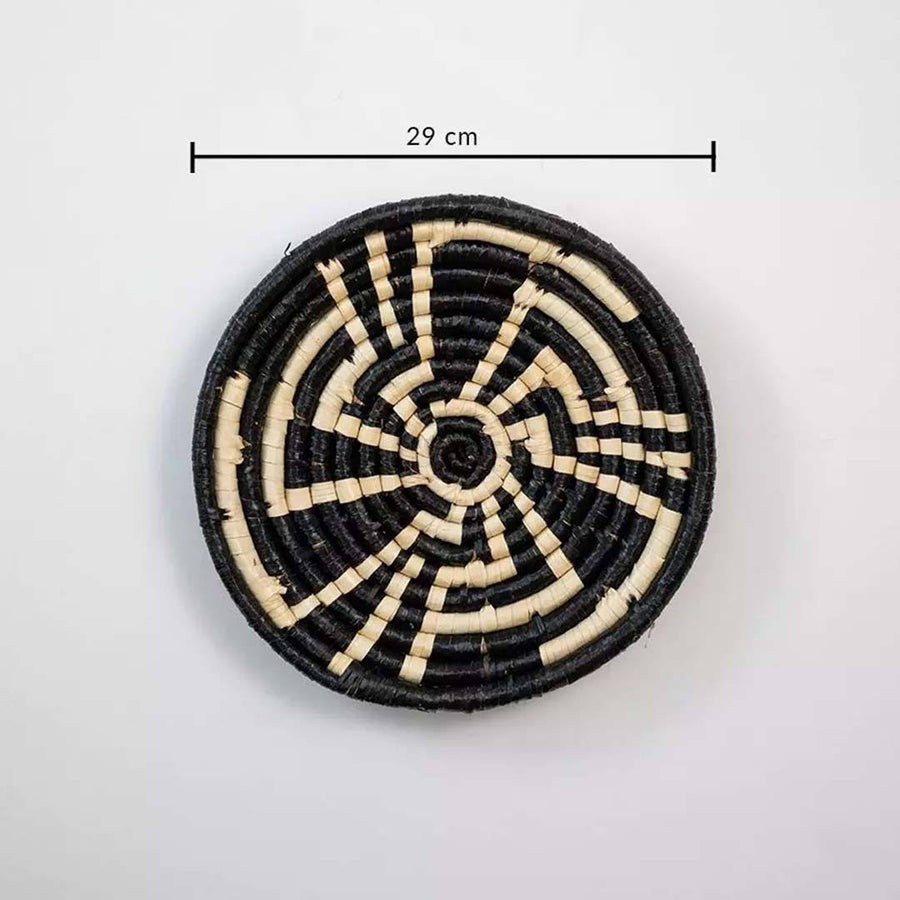 Round woven coaster with black and beige pattern on a white background, showing measurement label.