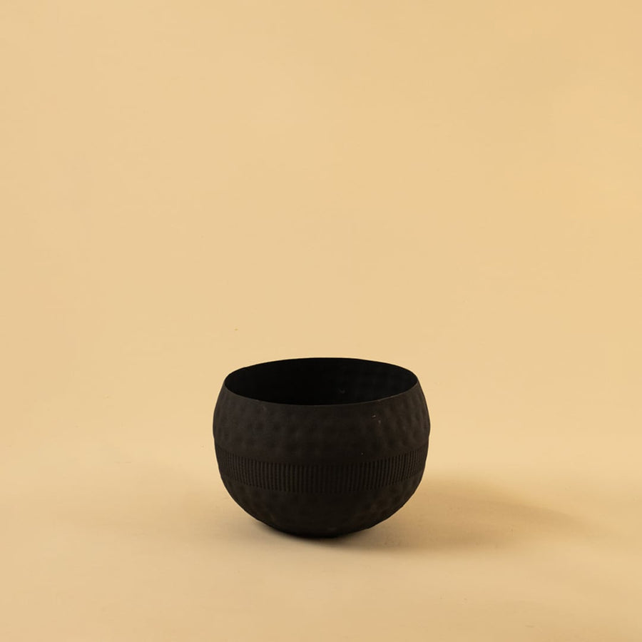 Black round textured planter bowl with matte interior photographed on a clean light background for a simple product display.