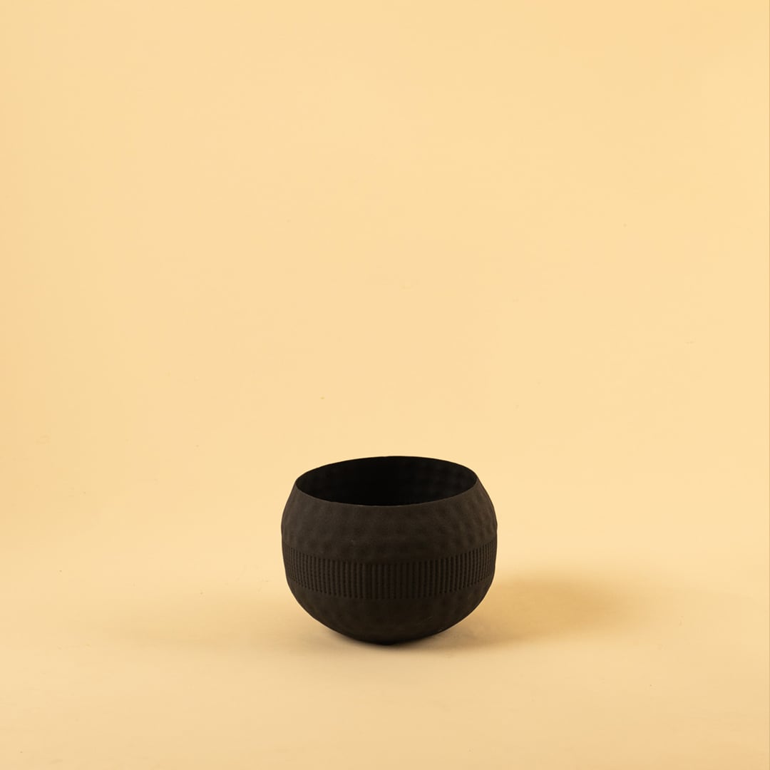 Black metal textured bowl decor on a clean white background showcasing its modern matte finish for versatile placement.