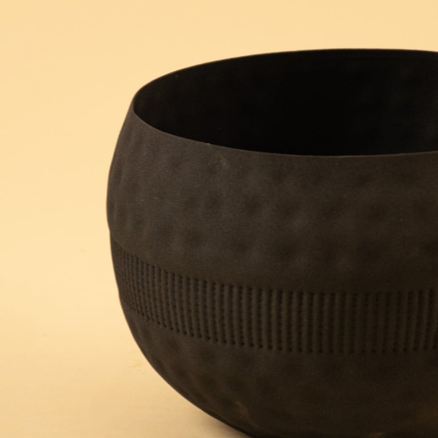 Closeup view of black textured planter bowl showing the detailed hammered texture and smooth matte interior.