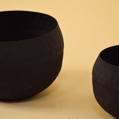 Closeup view of grouped black metal textured bowls showing detailed texture and rich matte finish for home styling.
