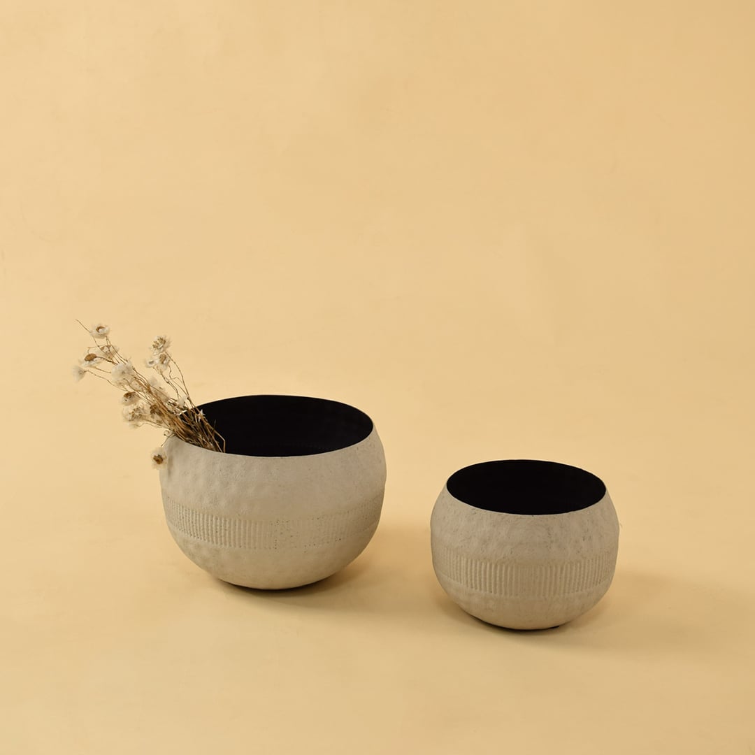 Cream textured pot displayed with coordinating pots in a warm interior creating a cohesive modern decorative setup.