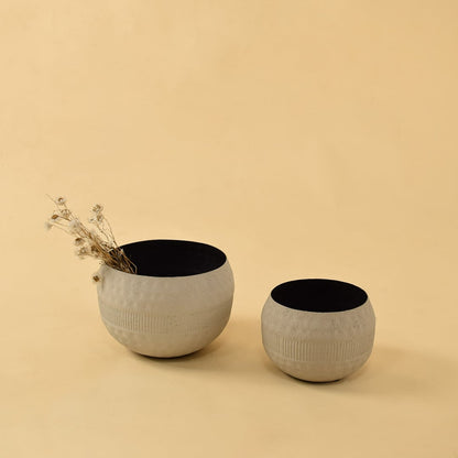 Cream textured pot displayed with coordinating pots in a warm interior creating a cohesive modern decorative setup.