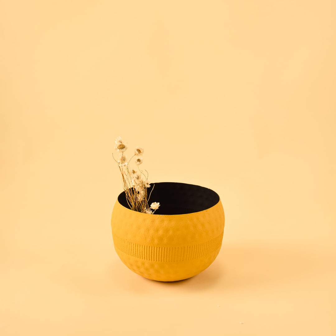 Yellow round textured pot with matte black interior styled in a modern home setting adding bright minimal decor to shelves and tables.