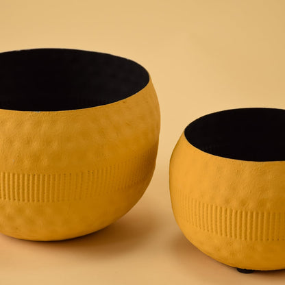 Closeup of yellow textured pot with black interior highlighting its detailed surface and modern handcrafted decor finish.