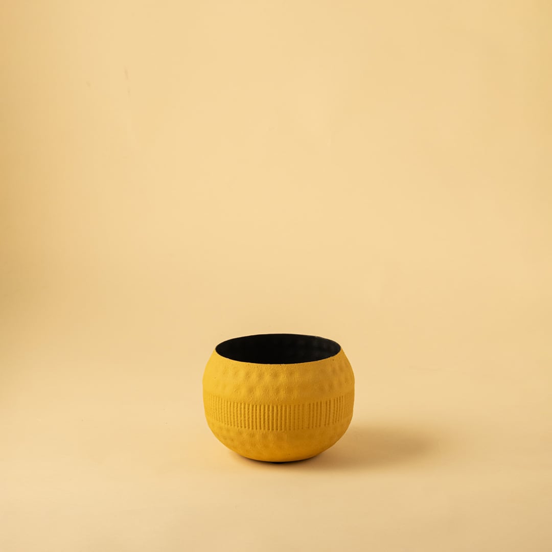 Yellow textured pot with matte black interior displayed on a clean white background for simple modern home decor styling.