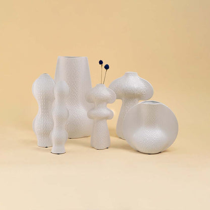 Set of modern white sculptural vases with unique artistic shapes arranged together creating a contemporary home decor look.
