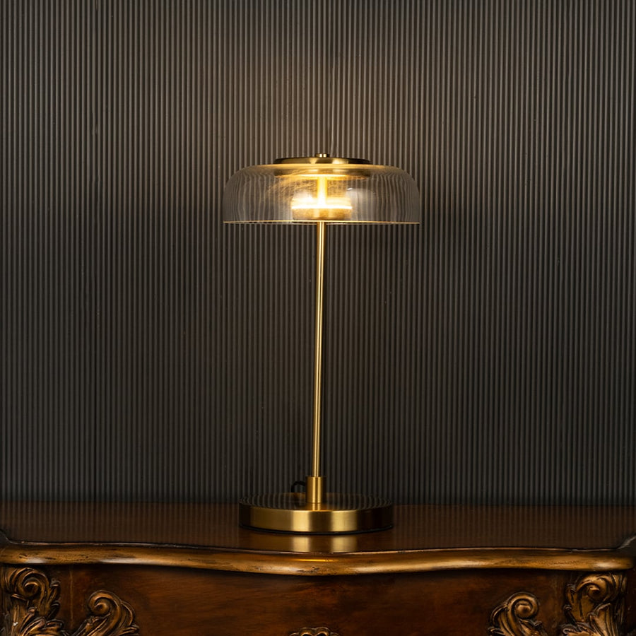 Gold and glass dome lamp with glowing shade shown on a black background creating a warm premium lighting effect for modern home decor.