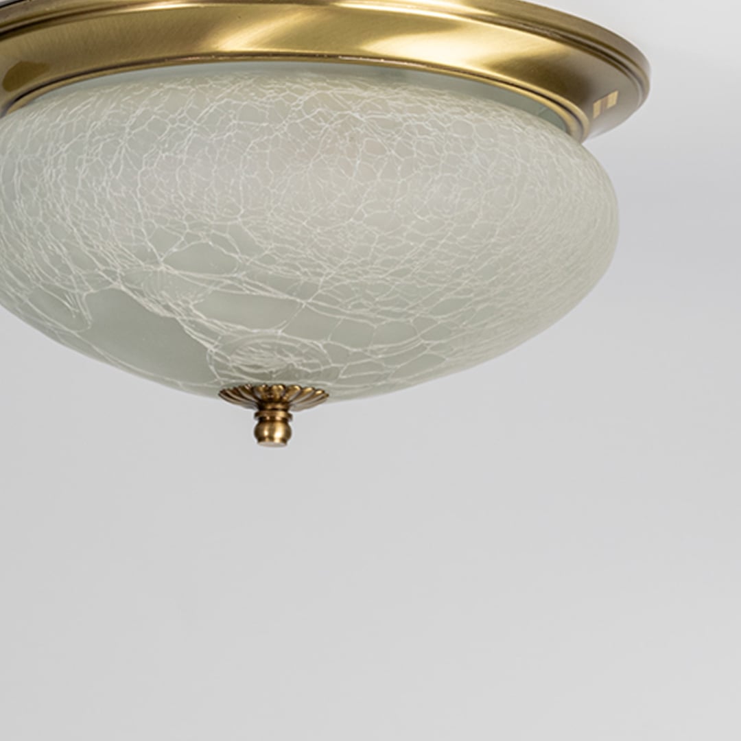 Closeup of textured frosted glass and antique brass ceiling light for premium traditional interior decor styling spaces.