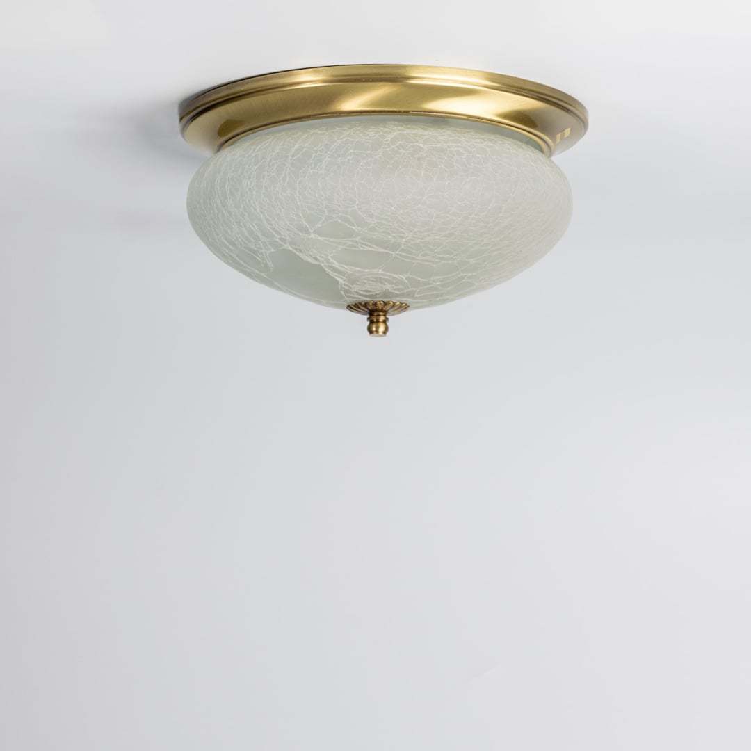 Modern antique brass flush mount ceiling light with textured frosted glass shade for elegant hallway and luxury decor spaces.