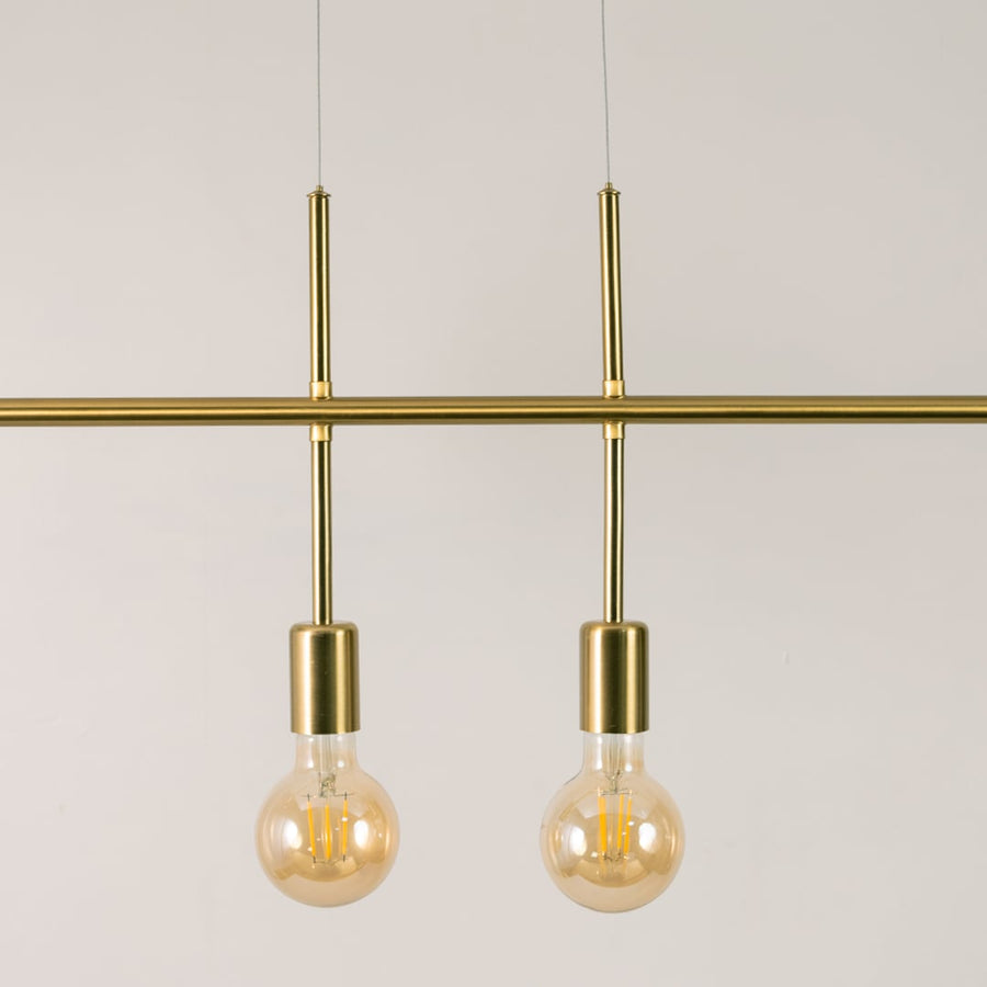 Detailed closeup of gold linear chandelier showing metallic finish bulb holders and smooth streamlined structure.