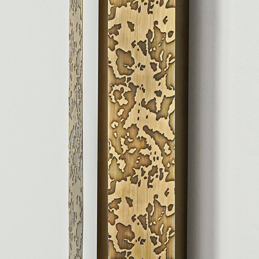 Close view of gold wall sconce with intricate textured metal detailing showcasing premium craftsmanship for elegant home lighting.