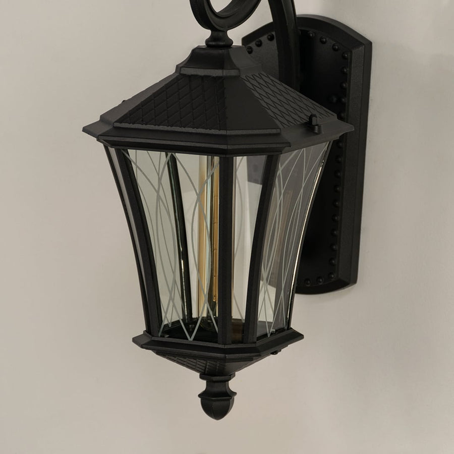 Closeup of black metal outdoor lantern showing patterned glass and detailed frame capturing its elegant vintage exterior styling.