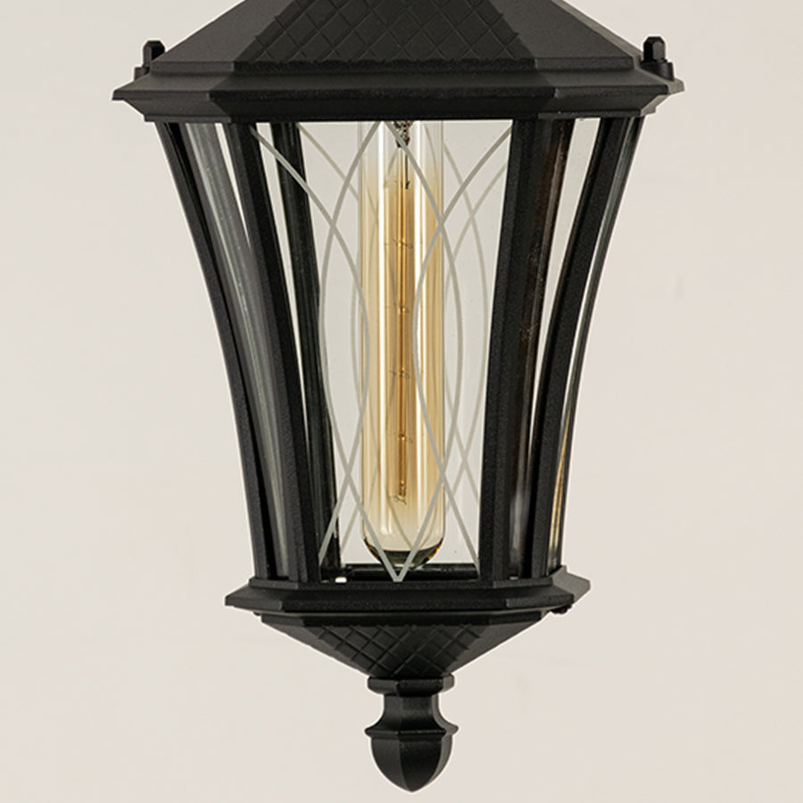 Closeup of black metal outdoor lantern with clear glass panels and bulb on white background ideal for premium exterior decor lighting.