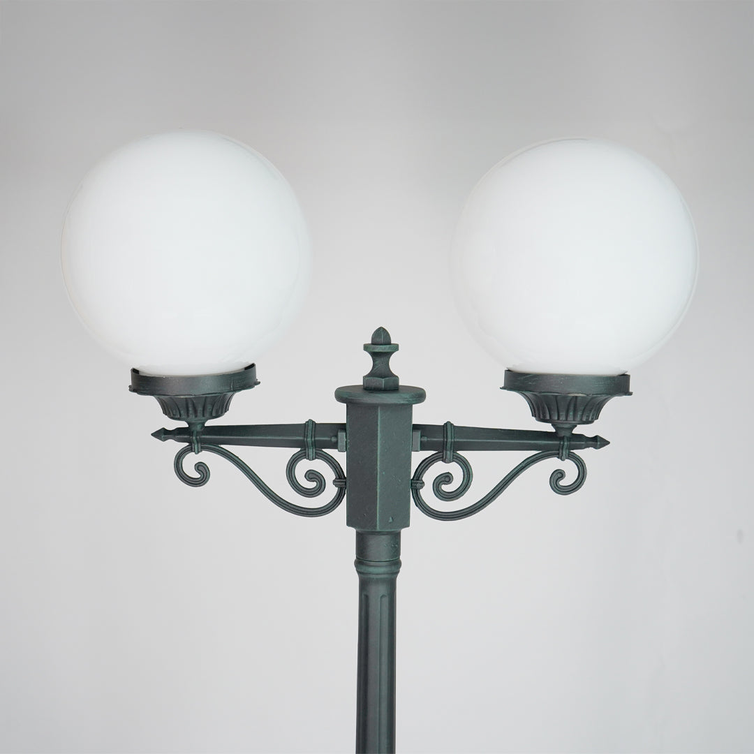 Closeup of vintage outdoor street lamp with dual frosted globe lights for elegant exterior decor styling.