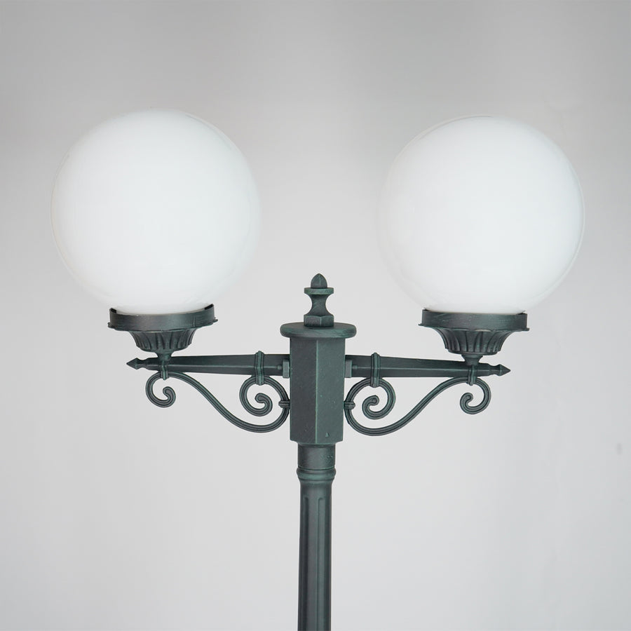 Closeup of vintage outdoor street lamp with dual frosted globe lights for elegant exterior decor styling.