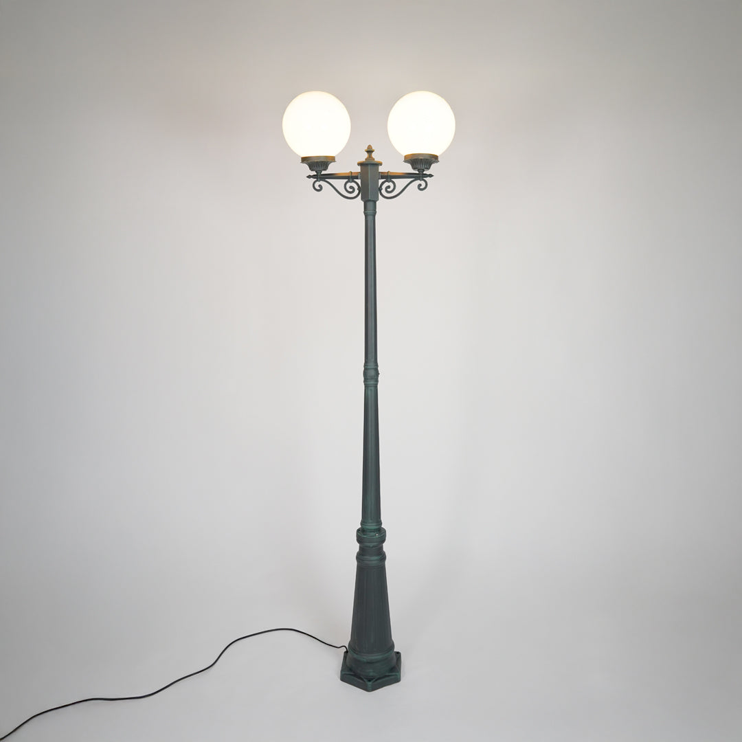Vintage black outdoor street lamp with glowing globe lights for luxury exterior decor styling.