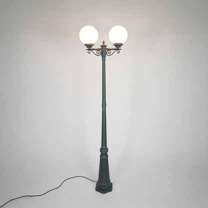 Vintage black outdoor street lamp with glowing globe lights for luxury exterior decor styling.