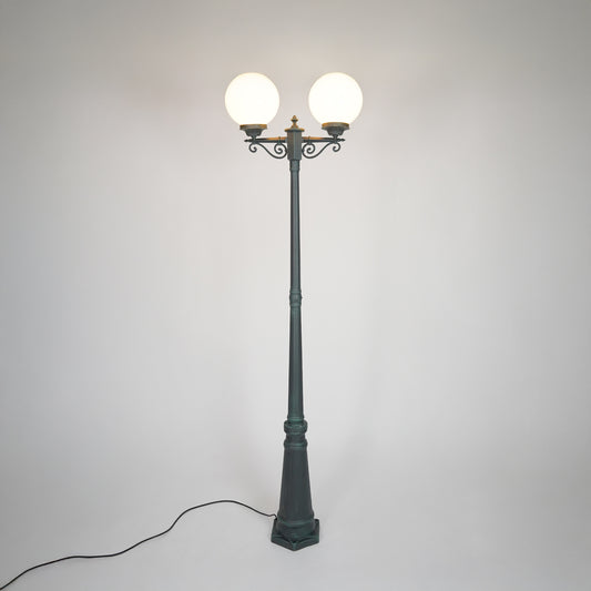 Vintage black outdoor street lamp with glowing globe lights for luxury exterior decor styling.