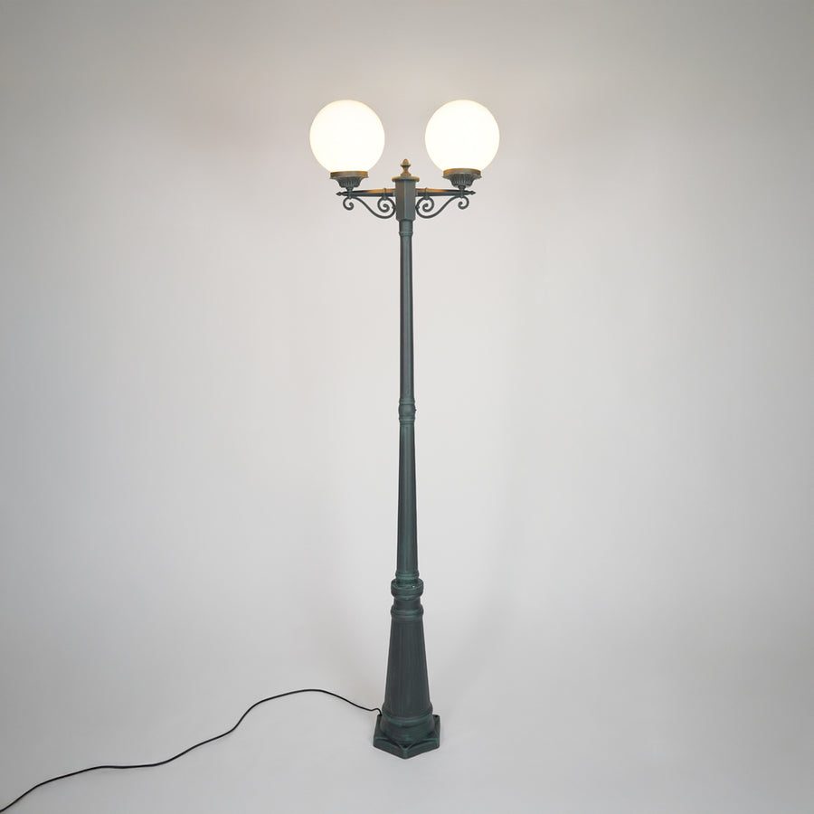 Vintage black outdoor street lamp with glowing globe lights for luxury exterior decor styling.