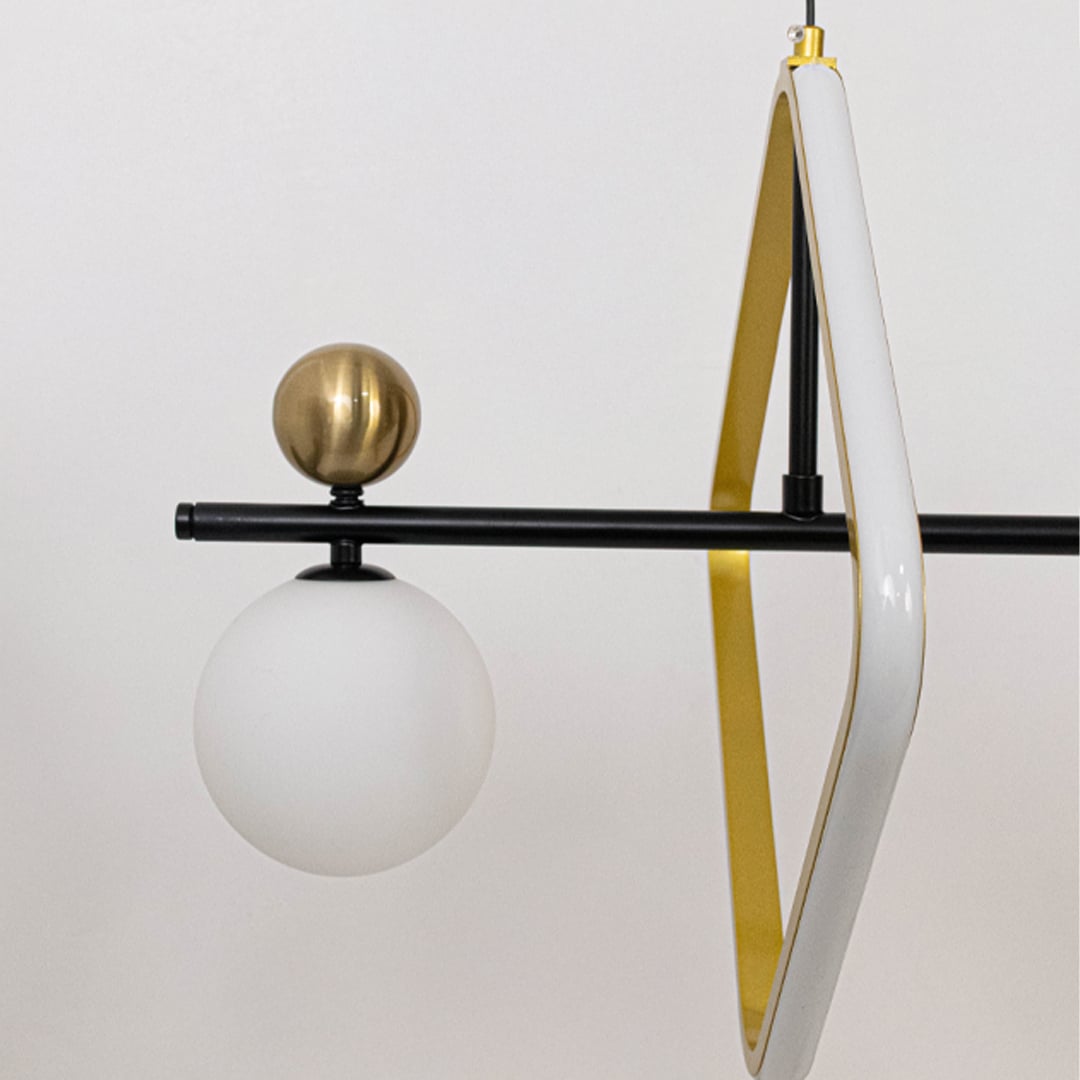 Closeup of modern wall light featuring black metal arm white glass globe and gold accent creating minimalist luxury design.