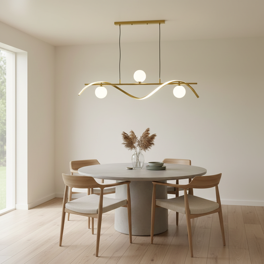 Gold metal chandelier with frosted glass globe shades above dining table creating elegant ambient lighting for modern interiors.