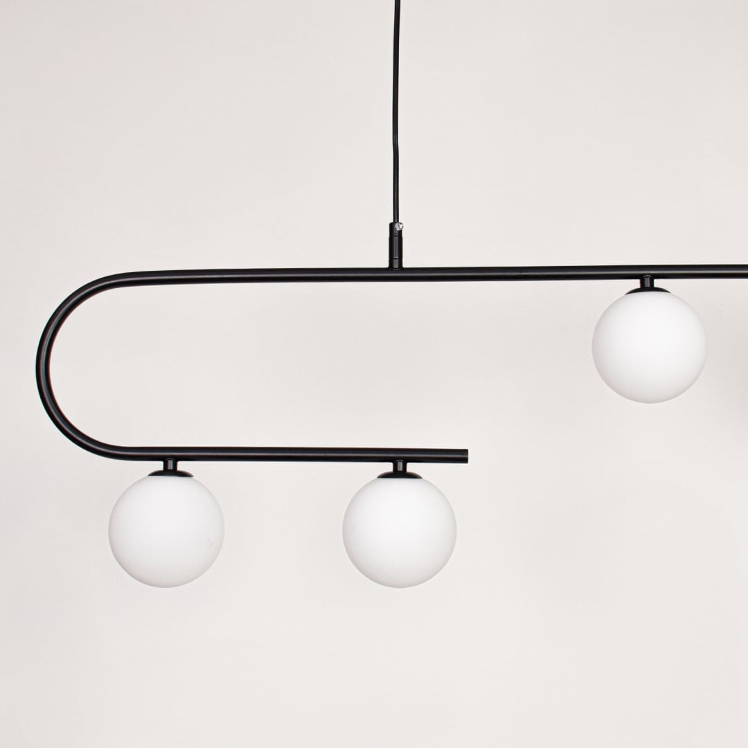 Black metal ceiling light closeup showing curved frame and frosted glass globe shades for modern contemporary interior lighting decor.