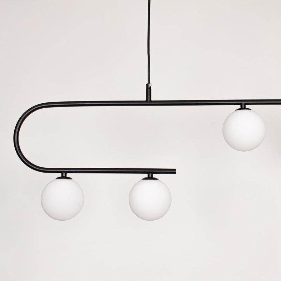 Black metal ceiling light closeup showing curved frame and frosted glass globe shades for modern contemporary interior lighting decor.