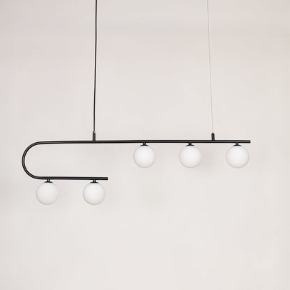Black metal linear pendant light with white glass globes switched off on white background for minimalist ceiling decor.