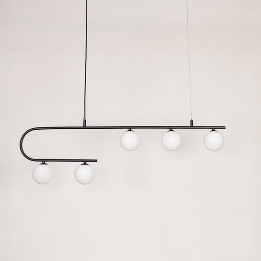 Black metal linear pendant light with white glass globes switched off on white background for minimalist ceiling decor.