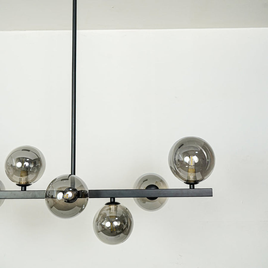 Smoked glass globe chandelier with black metal frame showcasing elegant craftsmanship and contemporary decorative lighting.