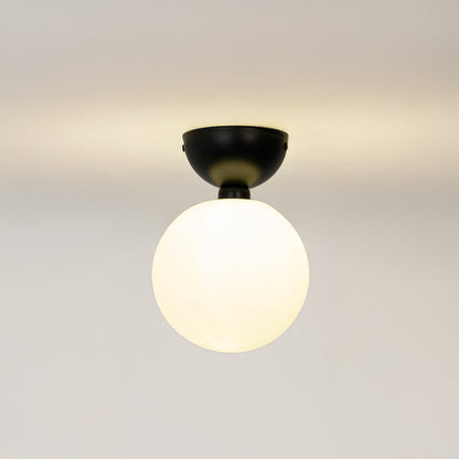 Modern black metal ceiling light with frosted white glass globe for contemporary bedroom and elegant decor styling spaces.