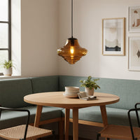 Amber ribbed glass pendant light above dining table creating warm ambient lighting for modern dining room interiors.