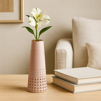 Pink ceramic vase with gold detailing placed on a white shelf adding a soft modern accent ideal for living room and bedroom decor.