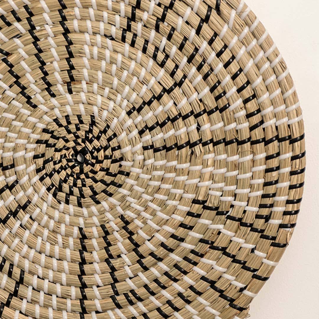 Detailed closeup of handcrafted black natural seagrass wall basket with geometric stepped zigzag pattern for boho decor.